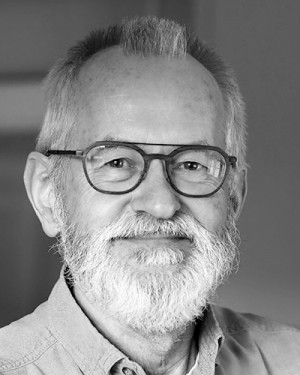 Portrett av eldre mann med grått skjegg og briller